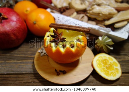Orange nectar - unusual served in orange. Orange flesh, spices, anise, cinnamon on old wooden table . Selective focus.