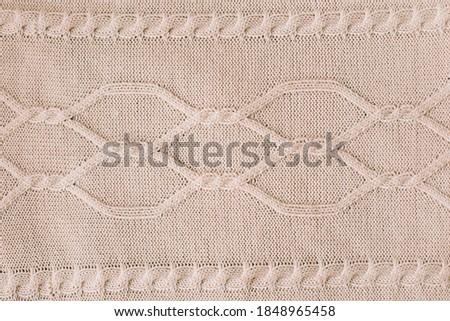 Knitting pattern of wool. Knitting. Texture of knitted woolen fabric for wallpaper and an abstract background.