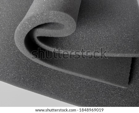 sheets of gray spongy foam with curved bends