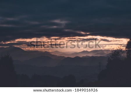 An aerial shot of mountain forest under cloudy night sky