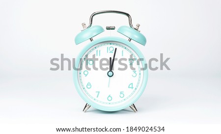 Blue Alarm clock Twelve o'clock isolated on white background.