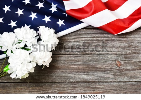 VETERANS DAY. MEMORIAL DAY. USA flag with white flowers on a wooden background. Flat lay, copy space. Independent day.