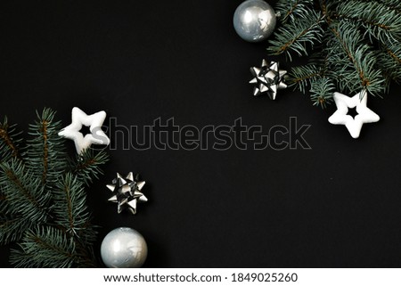 Christmas holiday composition. Festive Christmas decorations, silver toys, fir tree branches, confetti star on a black background. Banner mockup, postcard. Flat lay, top view. Copy space.