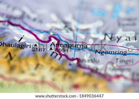 Shallow depth of field focus on geographical map location of Mount Annapurna in Nepal Asia continent on atlas