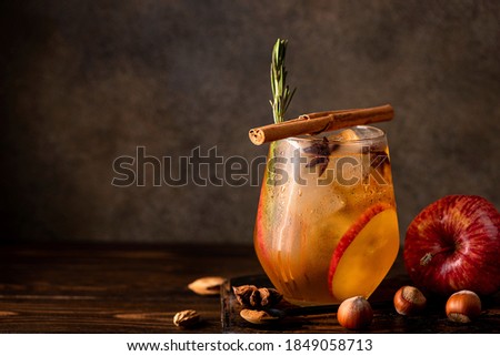 homemade apple cider with apple pieces, cinnamon and spices in a glass