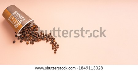 paper Cup with the words coffee, cappuccino, espresso. with coffee beans on a pink background, copyspace