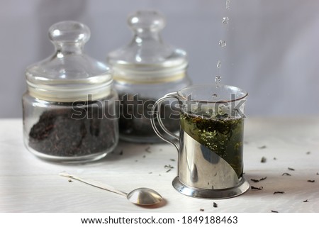Pour water into a Cup of tea. The process of making a drink.