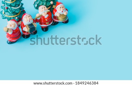 Flat lay Santa sing a song on Christmas caroling day Carolers singing with snows.Group of Santa claus play music singing carol song on celebration of christmas day in winter time.Holidays music.blue.