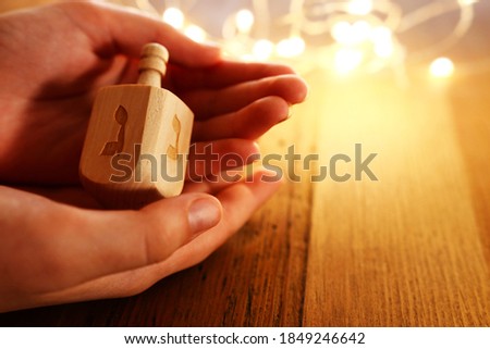 image of jewish holiday Hanukkah with wooden dreidel (spinning top) over wooden background