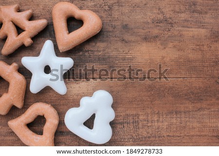 Christmas background with gingerbread cookies on wooden table. Top view, copy space. Rustic style. Traditional winter holiday pastry