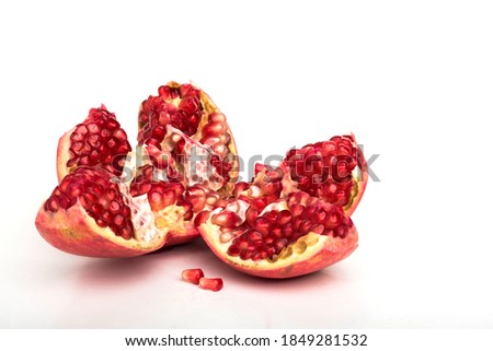 Broken garnet on a white background. Peeled pomegranate on a white background. Organic food. Food stock photo.