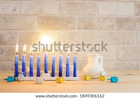 Image of jewish holiday Hanukkah with menorah (traditional Candelabra), donut and wooden dreidel (spinning top)