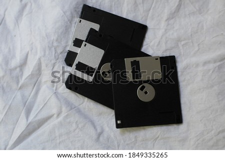 Computer floppy disk on white cloth background .