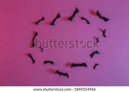 Flying paper cut bats in neon blue pink neon light. Halloween theme