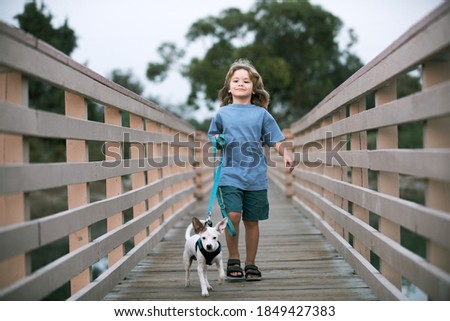 Kid and dog walk outdoors. Child with pet. Children walks with the puppy