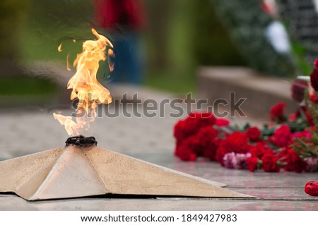 
eternal flame and flowers in memory of the fallen soldiers