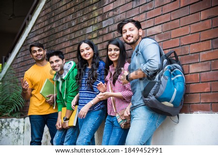 Cheerful Indian asian young group of college students or friends laughing together while sitting, standing or walking in campus Royalty-Free Stock Photo #1849452991