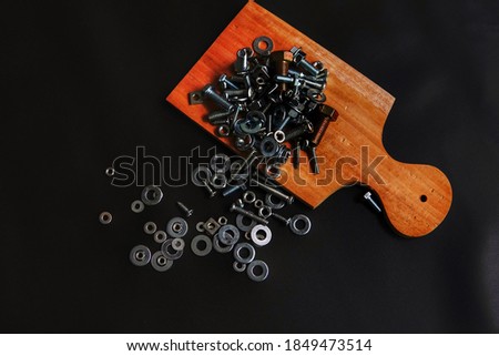 nuts and bolts scattered on top of the black board