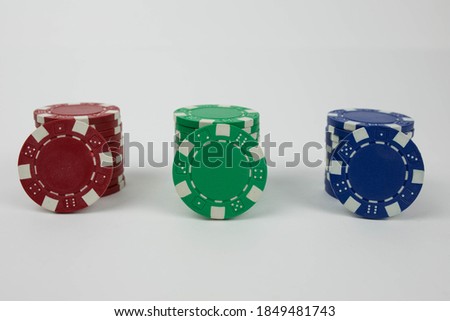 the red green and blue poker chip stacks with one chip for every color leaning on the stack