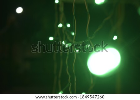 green single blurry light with black background and green lights and wires