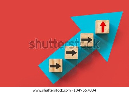 Business growth and Ladder of success concepts. Wooden blocks stacking as step stair with arrow up on red background