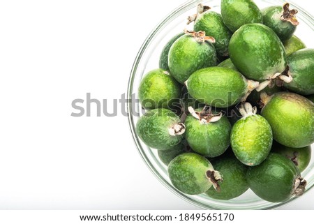Green feijoa fruit in a glass dish, isolated on a white background. Tropical feijoa fruit. Set of ripe feijoa fruits. the view from the top. Space for copying. Organic food. Vegetarian food. Food stock