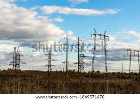 Rusty and black power line is on the blue sky with white clouds background