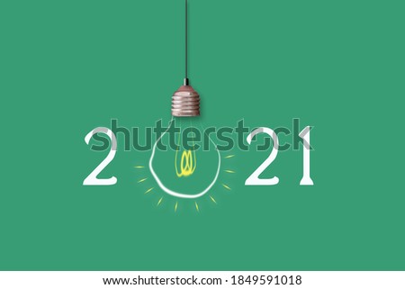 2021 Happy New Year. Light bulb on a green background. Festive background.