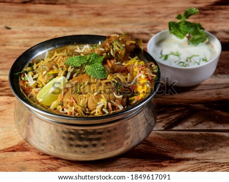 Traditional Hyderabadi Chicken dum Biryani made of Basmati rice cooked with masala spices, served with Onion raita, selective focus Royalty-Free Stock Photo #1849617091