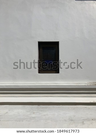 The window is in the middle of the white wall