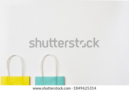 Yellow and blue paper gift bags on a white background. Copy space, flat lay, layout, top view