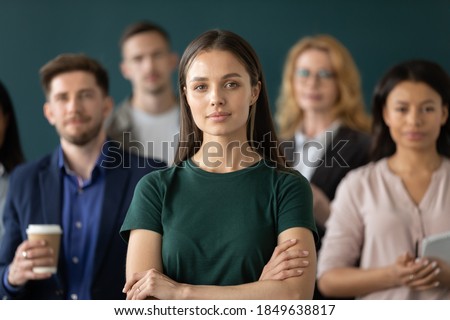 Corporate spirit. Portrait of happy millennial woman new employee worker intern looking at camera starting career having confidence in future proud glad of feeling part of big diverse multiethnic team Royalty-Free Stock Photo #1849638817