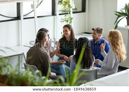 Business training. Group of positive inspired professional employees managers teammates sitting in circle at office space providing meeting training briefing, creating ideas, talking, sharing opinions Royalty-Free Stock Photo #1849638859