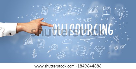 Close-Up of cropped hand pointing at OUTSOURCING inscription, modern business solution concept