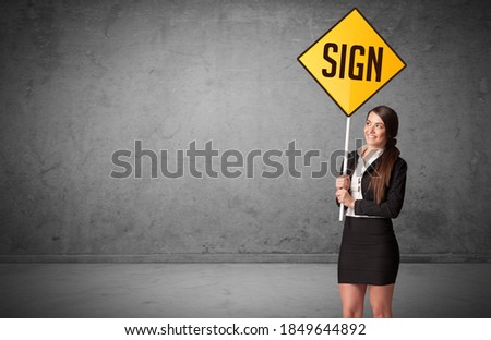 Young business person holding road sign with SIGN inscription, new rules concept
