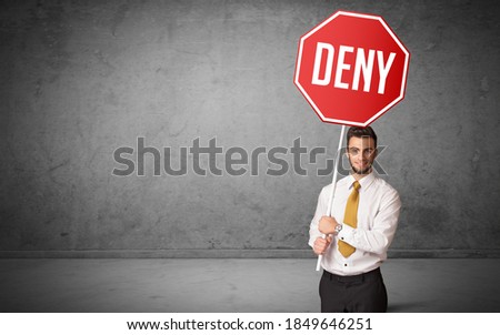 Young business person holding road sign with DENY inscription, new rules concept