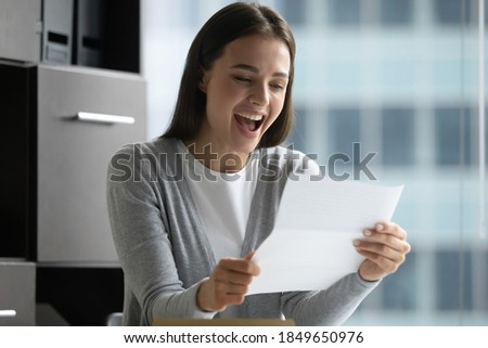 That is amazing! Overjoyed laughing young lady office manager employee reading formal paper message confirming full payment of credit loan, informing that her project research becoming grant recipient Royalty-Free Stock Photo #1849650976