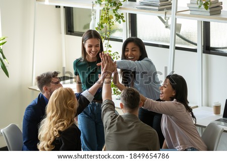 Together we are the power. Laughing excited business team colleagues of different age ethnicities join palms in high five on briefing at office feeling happy proud of mutual achievement meeting goal Royalty-Free Stock Photo #1849654786