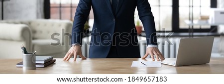 Horizontal cropped photo banner for website header design closeup young unrecognizable businessman in formal wear standing in office with hands put on table, professional services, leadership concept.