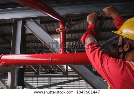 Install fire sprinkler system. In the industrial plant, pipe assembly, red fire pipe, fire protection contractors Using Scissor Lift High work Royalty-Free Stock Photo #1849681447