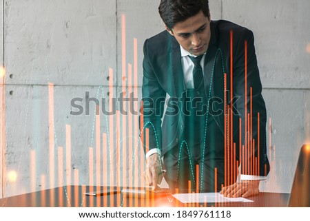 Businessman signs contract and financial chart hologram. Double exposure. Formal wear. Concept of brokerage.