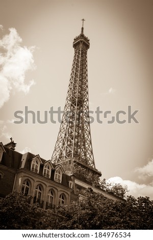 Eiffel tower and typical parisian house with mansards. Aged photo. Sepia. Shadowed angles.