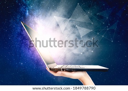 Close up of unknown man hand showing a laptop computer with connection network on milky way background