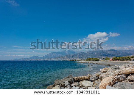 Seascape. Coastline and beach of the resort of Agios Nikolaos (Crete, Greece). Stock photo
