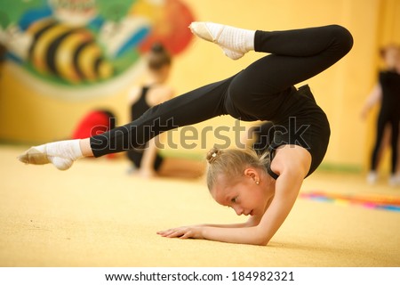 children athletes train in rhythmic gymnastics hall