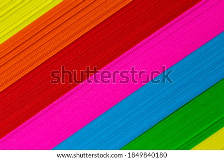 Multicolored sticky notes stacked in a pile. Evenly lit by artificial light