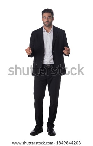 Full length portrait of young handsome business man in black suit holding something in hands studio isolated on white background