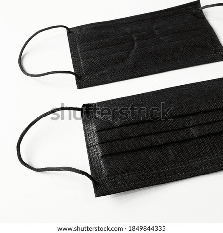 Unused medical black masks on a white background