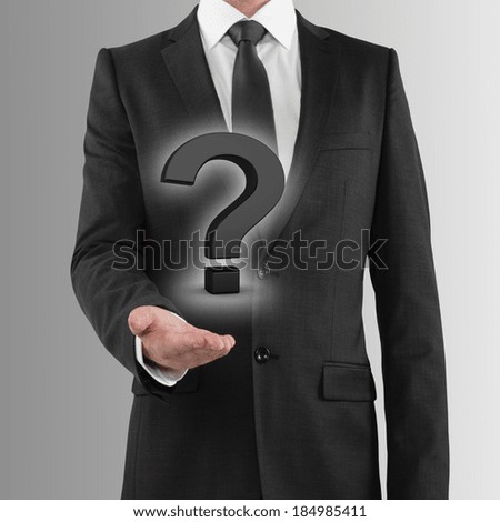 businessman holding black question mark