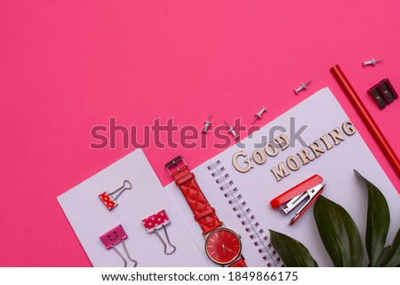 Modern office desk workplace with blank notebooks, wrist watch, pencil and office supplies on pink background. Lettering good morning. Copy space. Top view. Flat lay style. . High quality photo